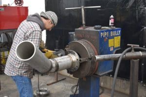 Technician grinding on pipe